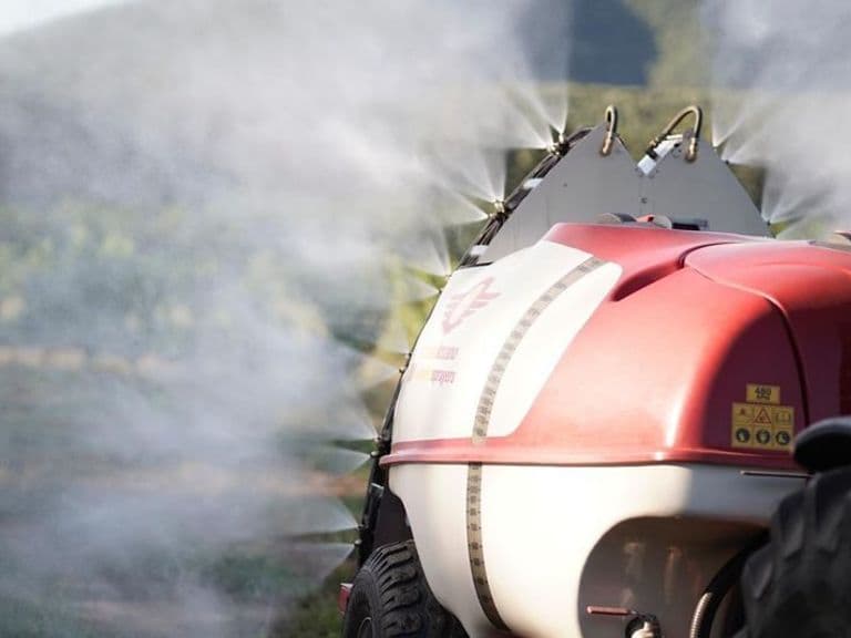 Imported mist blower spraying in an orchard